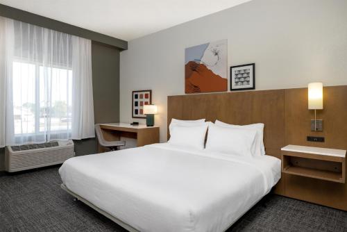 a hotel room with a large bed and a desk at Spark By Hilton Ames in Ames