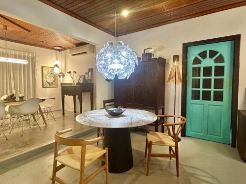 comedor con mesa y sillas y puerta azul en Chic Double Room Shared Bungalow near LRT SS1 PJ, en Petaling Jaya