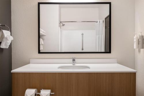 a bathroom with a sink and a mirror at Spark By Hilton Ames in Ames