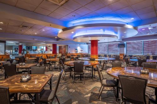 a restaurant with tables and chairs and a bar at Westmark Fairbanks Hotel and Conference Center in Fairbanks