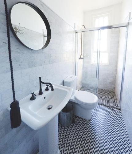 a bathroom with a sink and a toilet and a mirror at Hotel Palisade in Sydney
