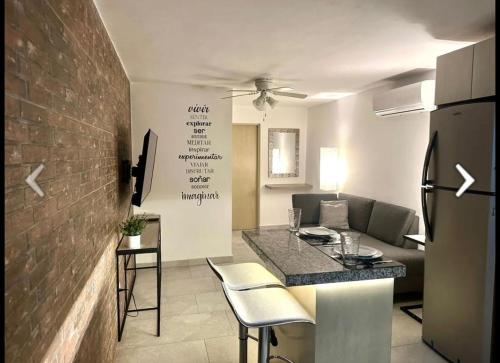 a kitchen and living room with a brick wall at Departamento Ejecutivo de Lujo in Monterrey