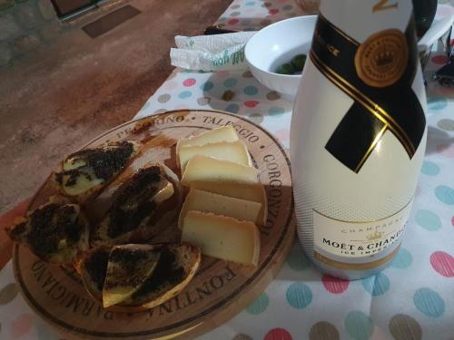 a plate of cheese and a bottle of wine at Masseria Marotta Appartamento in Santa Paolina