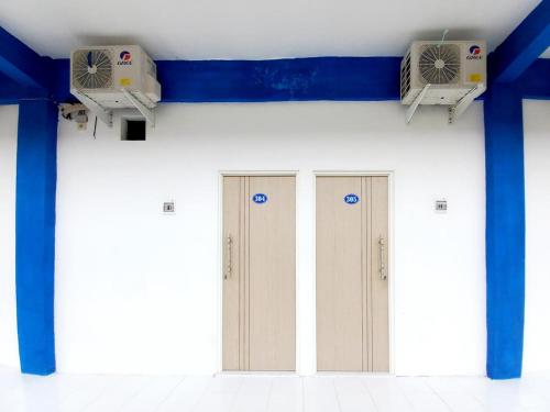 een rij deuren in een kamer met twee airconditioners bij Sky In Homestay Syariah near RSUD Sogaten RedPartner in Madiun