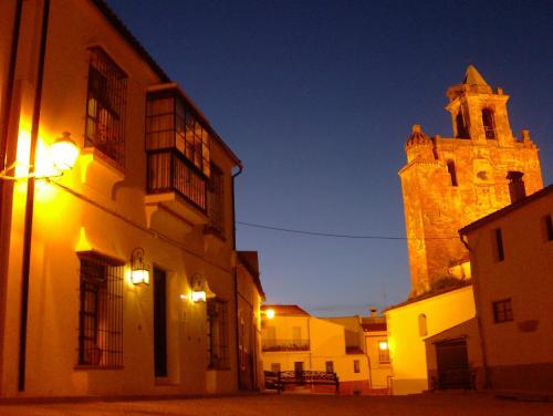 un edificio con una torre de reloj y una iglesia en Casa Rural y Restaurante Casa Adriano, en Alanís