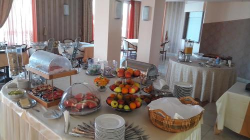 a buffet with fruits and plates on a table at Hotel Neva in Podstrana