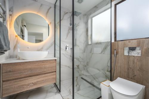 ein Badezimmer mit Dusche, Toilette und Waschbecken in der Unterkunft Opulent Haven, Designer Luxury, Expansive Space in Lower Hutt