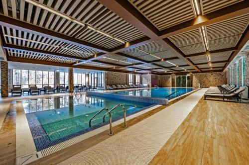 Green Wellness Burabay في بوروفوي: مسبح داخلي كبير مع مسبح كبير