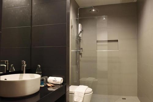 a bathroom with a sink and a shower and a toilet at INBED in Sadao