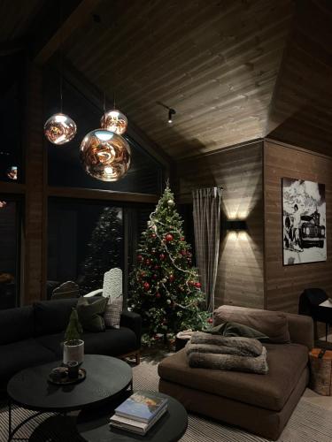 a living room with a christmas tree and a couch at New chalet with great view in Hafjell