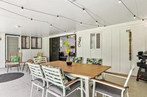 BuddinaにあるFamily Home Near Cafes and Surf Beachesの木製のテーブルと椅子のあるダイニングルーム
