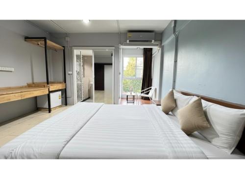 una camera da letto con un grande letto bianco in una stanza di Collection O Mahidol Road a Chiang Mai