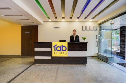 a woman is standing at a reception desk at FabHotel Tap Inn in Bengaluru