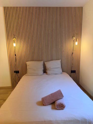 Un dormitorio con una cama blanca con dos toallas encima. en Le Clos d'AIX studio 1, en Aix-en-Provence