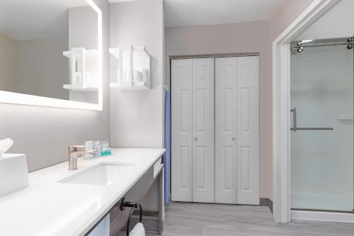 Un baño blanco con ducha y lavabo. en Hampton Inn Houston-Deer Park Ship Area, en Deer Park
