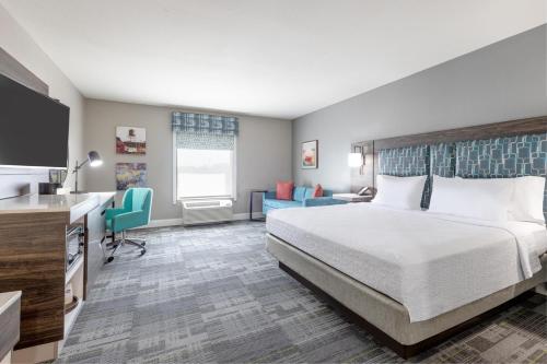Una habitación de hotel con una cama grande y una cocina. en Hampton Inn Houston-Deer Park Ship Area, en Deer Park
