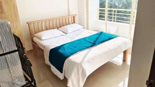 Un dormitorio con una cama con una manta azul encima. en Dodamarg Heights, en Dodamarg