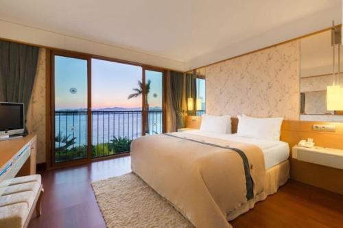 una camera da letto con un letto con vista sull'oceano di Kefaluka Resort a Akyarlar