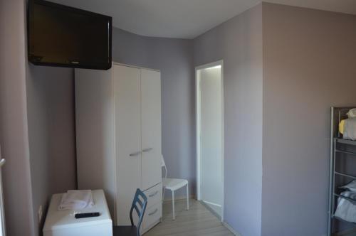 ein Badezimmer mit einem weißen Schrank und einem TV an der Wand in der Unterkunft Hôtel Restaurant Le Bellevue in Ax-les-Thermes