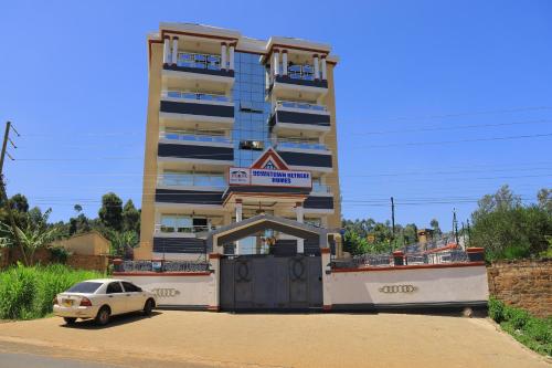 ein Gebäude mit einem davor geparkten Auto in der Unterkunft Downtown Retreat Homes in Kisii