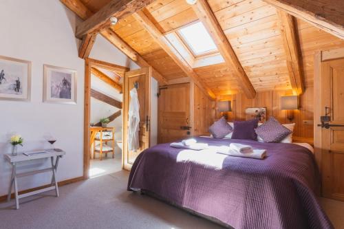 a bedroom with a large bed and a wooden ceiling at La Ferme a Mamy - Snowytrees in Morzine