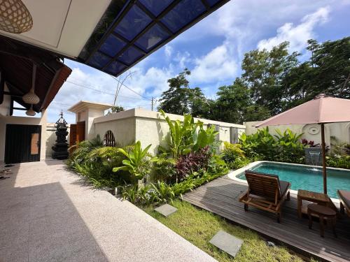 a backyard with a swimming pool and a house at Wanaseta Guesthouse in Uluwatu