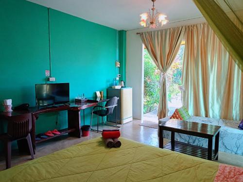 a room with a bed and a desk with a television at Six Nature Resort in Chiang Rai