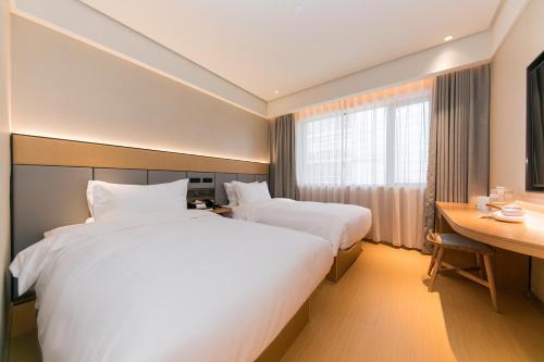 Ένα ή περισσότερα κρεβάτια σε δωμάτιο στο JI Hotel Shanghai Xujiahui
