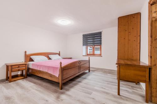 a bedroom with a bed and a wooden dresser at Holiday Home Pr'Lukčevih with 4 Bedrooms & Sauna in Kanal