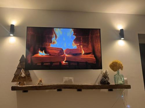 a flat screen tv on a wall with a fireplace at Apartamento La Sabina in Reinosa