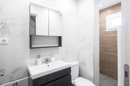 a white bathroom with a sink and a toilet at Panorama Sunvilles Apartment 9 in Thessaloniki