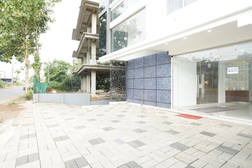 a building with a tile floor and a window at Staymax Parassinikadavu in Parassinikadavu
