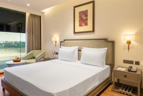 a bedroom with a large white bed and a window at Clarks Inn Kharar-Mohali in Kharar