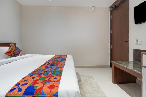 a bedroom with a bed with a colorful blanket on it at FabHotel Eraya in Varanasi