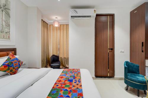 a hotel room with a bed and a chair at FabHotel Eraya in Varanasi