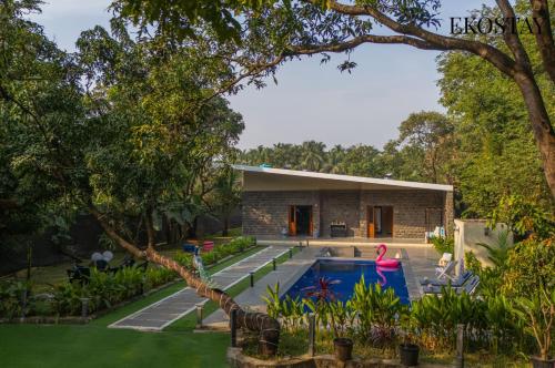 a house with a swimming pool in a yard at EKOSTAY - The Clay House in Alibaug