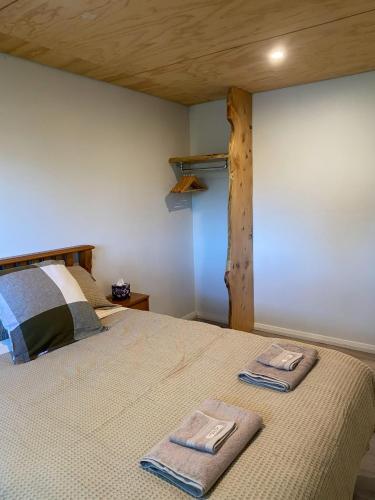 a bedroom with a bed with two towels on it at Birchwood in Wanaka
