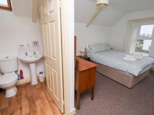 Wayside Cottage في نيوتون باي ذا سي: غرفة نوم بها سرير ومغسلة ومرحاض