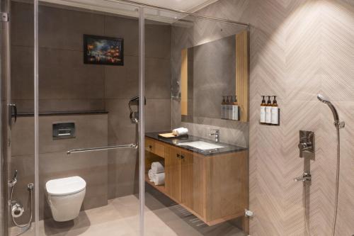 a bathroom with a shower and a toilet and a sink at Clarks Inn Kharar-Mohali in Kharar