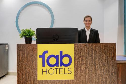 Un hombre de pie detrás de un podio con un cartel de Aida Hotels. en FabHotel Golden Nest Deluxe - Nr Calangute Beach, en Old Goa