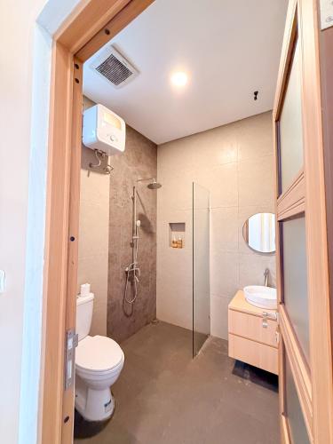 a bathroom with a toilet and a shower and a sink at Wanaseta Guesthouse in Uluwatu