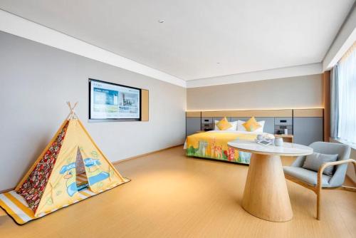 ein Schlafzimmer mit Bett und Tisch und ein Zimmer mit einem Zelt in der Unterkunft JI Hotel Chongqing Yufu Industrial Park TuoXinXing Times in Chongqing