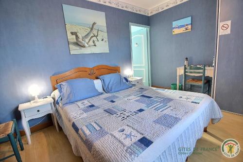 ein Schlafzimmer mit einem großen Bett mit blauen Wänden in der Unterkunft Beau soleil in Aucaleuc