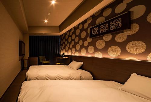 a hotel room with two beds and a wall at Sansuien in Kochi