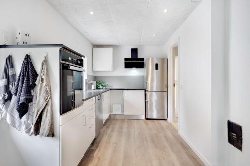 a kitchen with white cabinets and a refrigerator at Villa Surrounded By Nature in Vissenbjerg