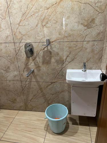 a bathroom with a sink and a bucket at Nestdormitory in Cochin