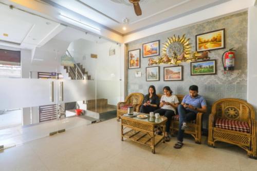 FabHotel Triveni في Jahāngīrābād: مجموعة من الناس جالسين على أريكة في غرفة