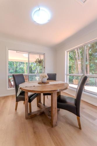 a dining room with a wooden table and chairs at The Nature Nook in Upper Mudgeeraba