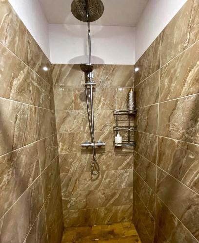 a bathroom with a shower with brown tiles at Sodyba Viltis in Bikavėnai