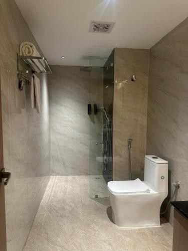 a bathroom with a toilet and a glass shower at Hotel The Royal Keshar-Near Bhutan Border in Jaigaon
